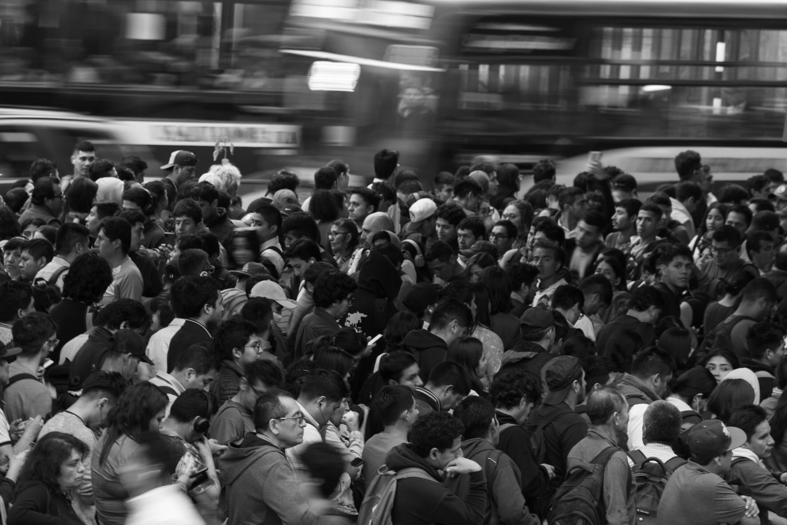 A dense, monochrome crowd navigating city streets, reflecting urban life.